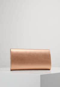 Metalická růžově zlatá kabelka s hladkým povrchem, obdélníkovým tvarem a bez viditelných uzavření nebo detailů z kovu.