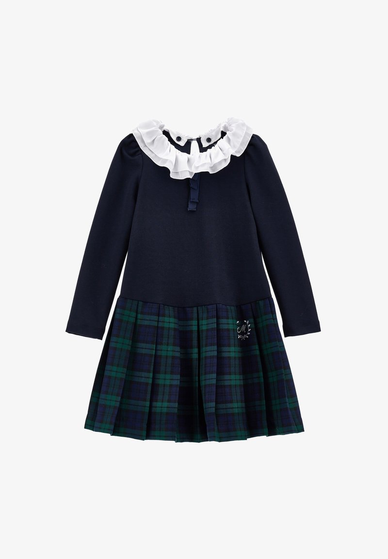 Robe marine à manches longues, col blanc à volants, et jupe plissée à carreaux verts et bleus avec un petit détail brodé.