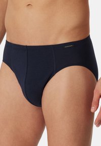 Herren Slips in Marineblau, aus weicher Baumwolle mit glatter Textur. Mit einem markierten Bund und klassischem Design.