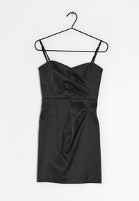 Černé saténové mini šaty s výstřihem do tvaru srdce, tenkými nastavitelnými ramínky, nařasením po celé těle a hladkou strukturou. Visí na černém háčku.