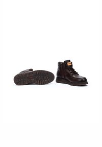 Bottes en cuir marron avec une tige haute, design à lacets, col rembourré et semelle en caoutchouc texturée. Comprend un accent logo sur la languette.