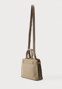 Beežist nahast käekott struktuurse disainiga, kahetega ülemise käepidemega, eemaldatava õlarihmaga ja kuldse tooniga metalldetailidega.