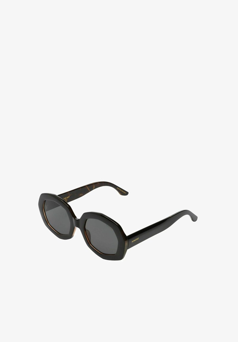 Lunettes de soleil octogonales noires et écaille de tortue avec verres sombres, présentant une finition brillante et un détail de marque sur les branches.