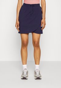 Námořnická modrá zavinovací sukénka s elastickým pasem a nastavitelnou šňůrkou, se hladkým povrchem a délkou ke kolenům.