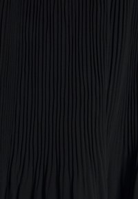 Tela negra con pliegues que presenta rayas verticales y una apariencia texturizada y fluida. El material es suave y tiene una sensación ligera.