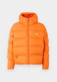 oranžová puffer bunda s vysokým golierom, zipsom na prednej strane a bielou logom nášivkou. Má prešívaný design a karabínku na leme.