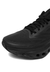 Nahaufnahme eines schwarzen Reebok Laufschuhs mit Mesh-Obermaterial, gemusterten synthetischen Überzügen, schwarzen Schnürsenkeln und einem belüfteten Sohlen-Design.