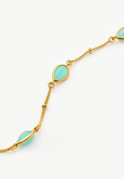 Χρυσό βραχιόλι με αλυσίδα και συνδεδεμένες σταγόνας σε σχήμα τουρκουάζ πέτρες σε λευκό φόντο.