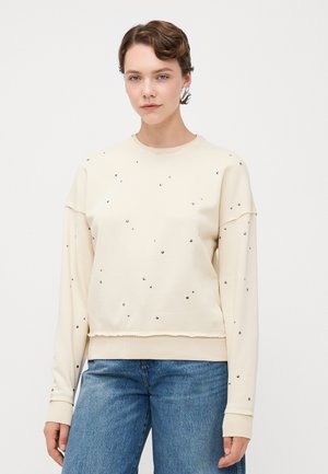 Cream-colored sweatshirt with a round neckline, embellished with small metallic accents, featuring a relaxed fit and ribbed cuffs.