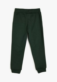 Pantalones de chándal de color verde oscuro con cintura elástica, puños ajustados, textura suave y un diseño simple. No presenta bolsillos ni adornos.