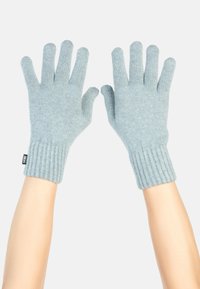 Ljusblå stickade handskar med ribbade manschetter. Femfingersdesign, mjukt material och en liten svart etikett på manschetten.