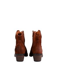Botas cortas de ante marrón con un tacón apilado, cremallera lateral y puntera redondeada. El diseño presenta costuras decorativas para un detalle adicional.