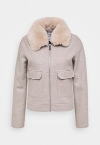 Beige jacka med fusk pälskrage, dragkedjestängning, två framfickor och långa ärmar, med en slät textur och skräddarsydd design.