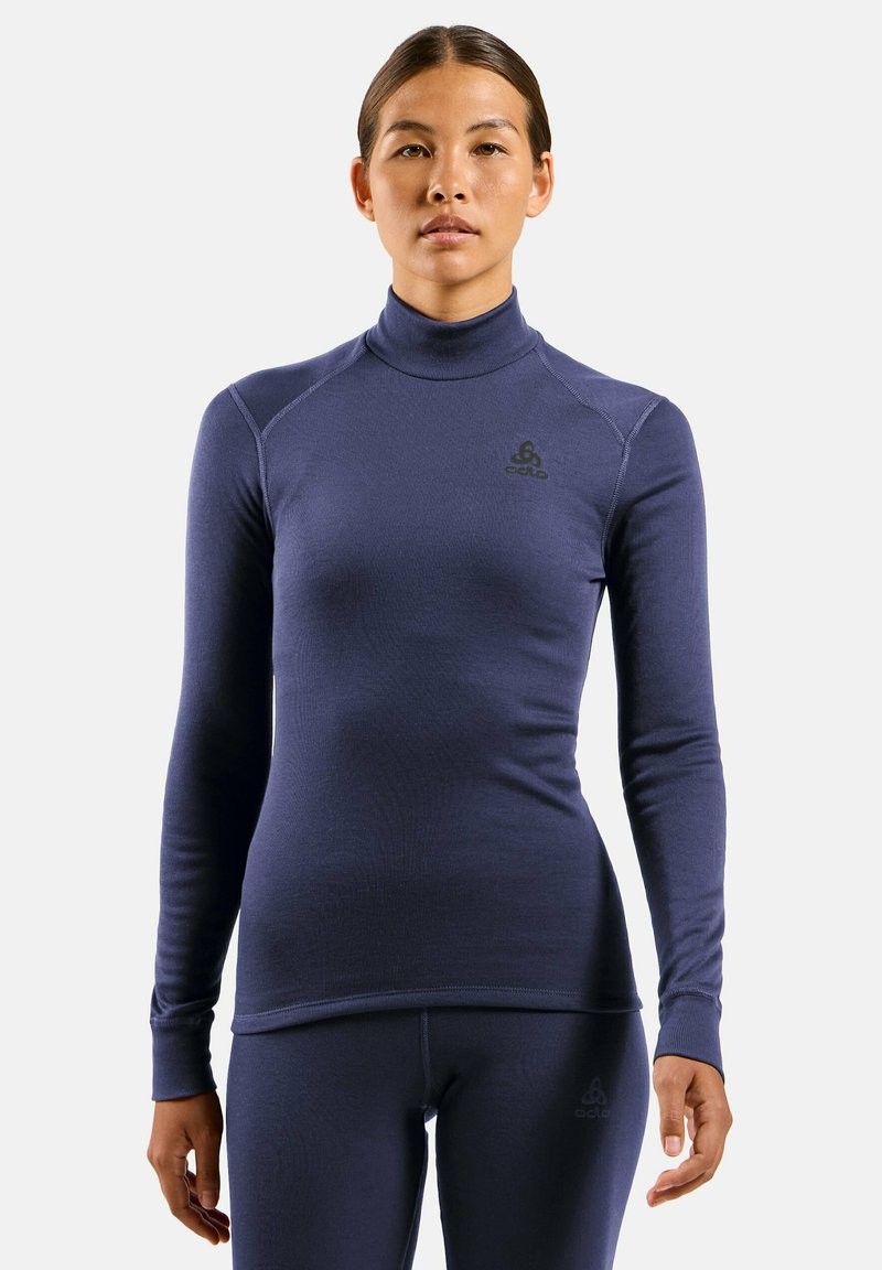 Navy long-sleeve base layer with a high neckline, textured fabric, and flat seams. Features a small logo on the chest and fitted design.