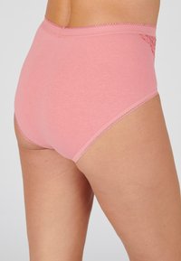 Hochgeschnittene, rosa Baumwollunterwäsche mit Spitze und gewelltem Saum, die eine glatte Textur und einen engen Sitz bietet.