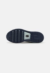 Semelle d'une chaussure Nike Air bleu foncé avec une semelle texturée, des rainures horizontales et un petit logo Nike swoosh au centre.