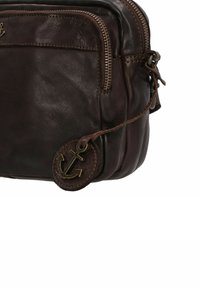 Borsa in pelle marrone con superficie texture, dotata di una tasca frontale con zip e un'etichetta rotonda con un'emblema di ancora attaccata.