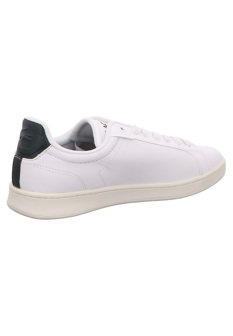 Białe skórzane sneakersy o gładkiej fakturze, z ciemnozielonym akcentem na pięcie, płaskimi sznurówkami i gumową podeszwą.