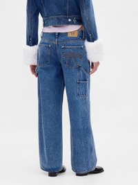 Bredde ben jeans i blått med denimfinish, med høy midje, flere lommer og en karakteristisk sløyfedetalj på baklommen.