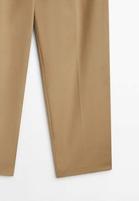 Pantalon beige droit avec une finition lisse, présenté de la mi-cuisse à l'ourlet sur fond blanc.