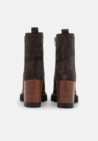 Botas de ante hasta el tobillo en gris oscuro, con punta redondeada, tacón de bloque de madera y cremallera dorada para facilitar su uso.