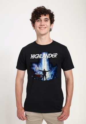 Černé bavlněné tričko s barevným grafikou postavy se mečem a vintage autem, s textem "HIGHLANDER" nahoře.