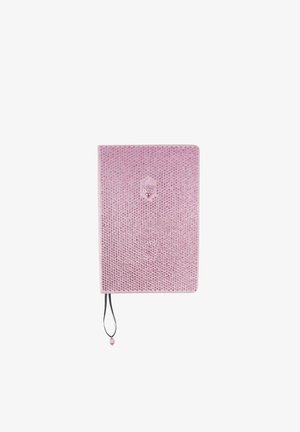 Quaderno rosa con copertina strutturata con decorazioni circolari, un logo al centro e una chiusura elastica nera con un ciondolo decorativo.