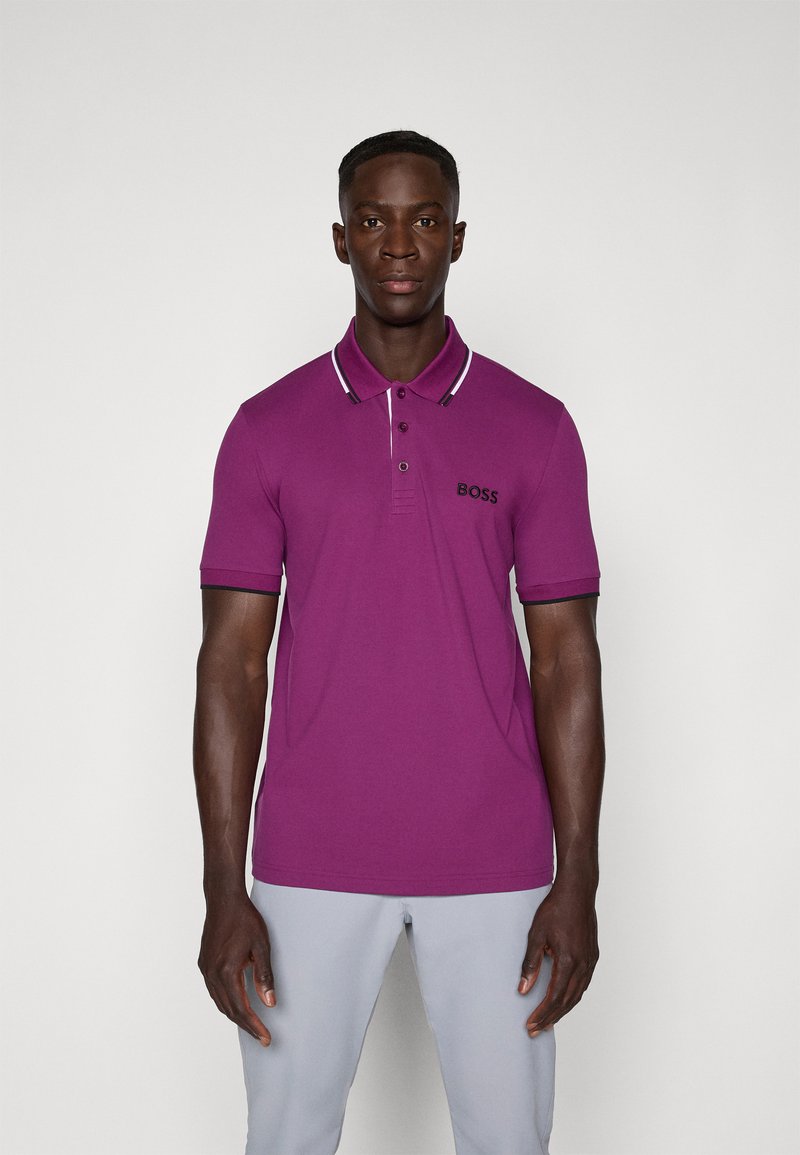 Vijolična polo majica z ovratnikom v beli in črni črtasti vzorci, kratkimi rokavi ter izvezenim logotipom "BOSS" na prsih. Gladka bombažna tekstura.