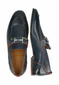 Niebieskie skórzane mokasyny mają gładkie wykończenie, pomarańczowe przeszycia oraz srebrny detal z klamrą na przednim pasku.