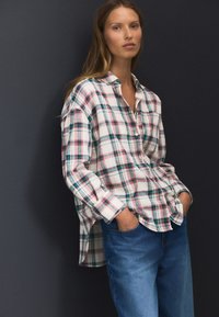 Camicia a maniche lunghe a quadri in bianco, blu, rosa e verde, con collo button-down e vestibilità comoda, abbinata a jeans blu.