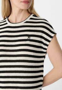 Gestreepte gebreide top in zwart en wit, met korte mouwen, een ronde hals en een klein geborduurd logo op de borst.