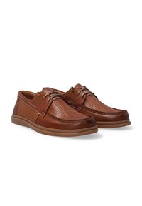 Bruine leren schoenen hebben een geperforeerd ontwerp, vetersluiting aan de voorkant en een gladde textuur met een gevoerd zool. Tijdloos en functioneel.