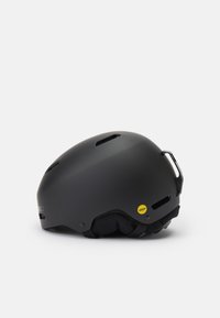 Černá helma s matným povrchem, vybavená ventilačními otvory, štítkem MIPS a polstrovaným interiérem pro pohodlí. Kompaktní oválný tvar.