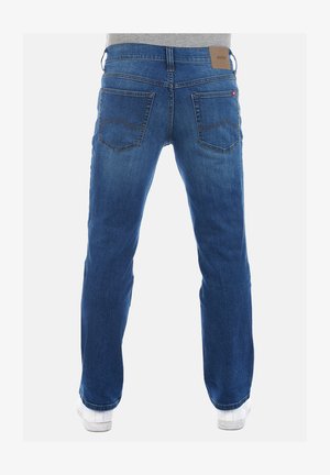 Dunkelblaue Jeans mit gerader Passform, fünf Taschen und einem Lederpatch am Bund. Mit dekorativen Nähten auf den Gesäßtaschen.