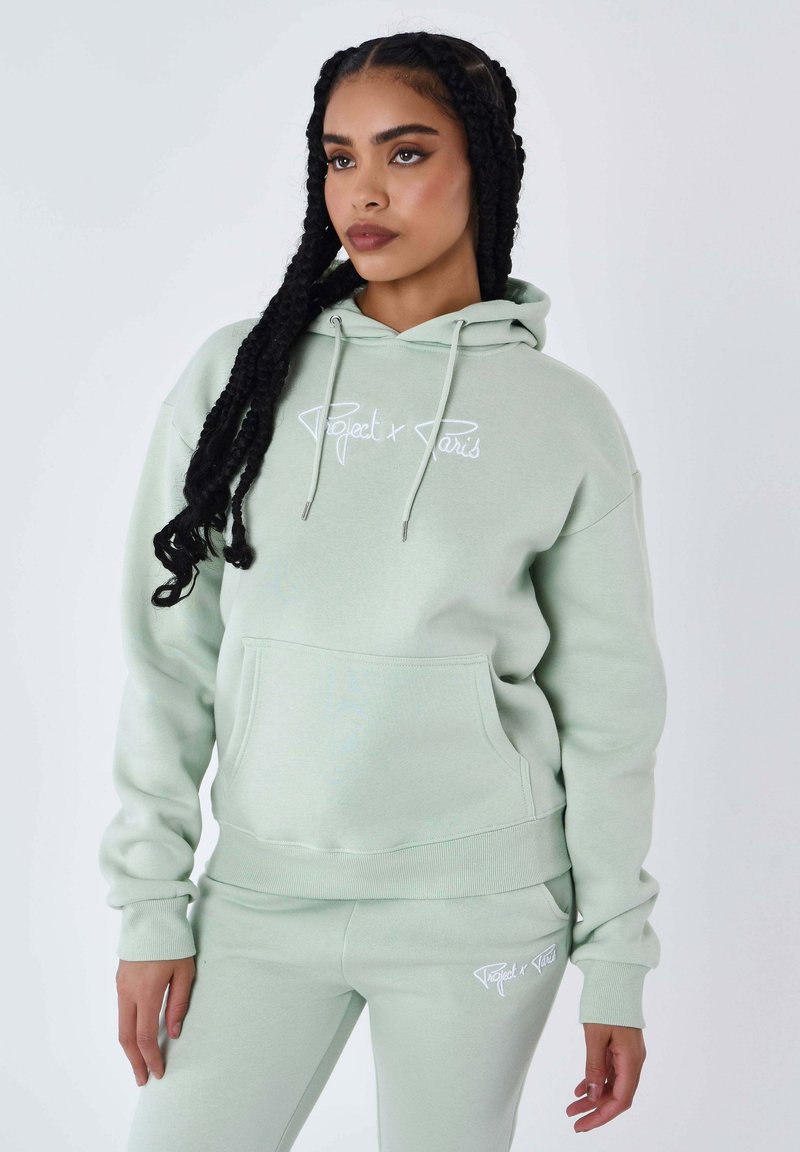 Felpa verde menta con tasca frontale, logo bianco "Project x Paris" e lacci. Abbinata a pantaloni verde menta coordinati.