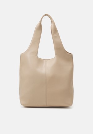 Beige leren totebag met brede handgrepen en een centrale verticale naad, ontworpen om over de schouder te dragen tegen een witte achtergrond.
