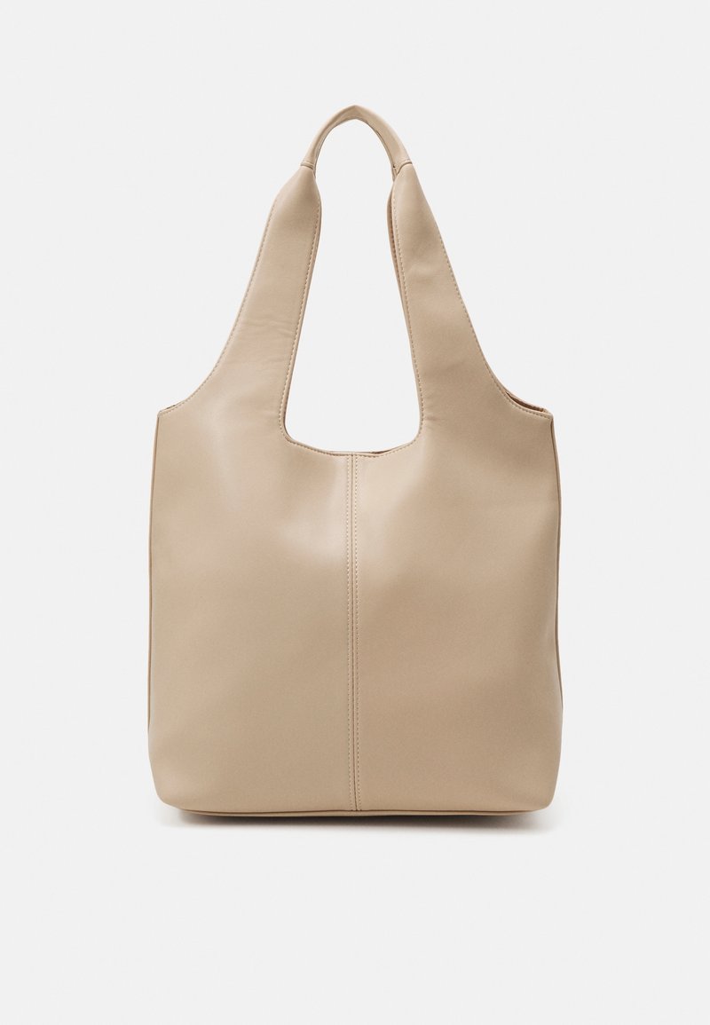 Sac fourre-tout en cuir beige avec des poignées larges et une couture verticale centrale, conçu pour être porté à l'épaule sur un fond blanc.