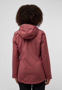 Veste imperméable bordeaux avec une capuche ajustée, des manches longues et une texture lisse. Présente une taille cintrée et un design minimaliste.
