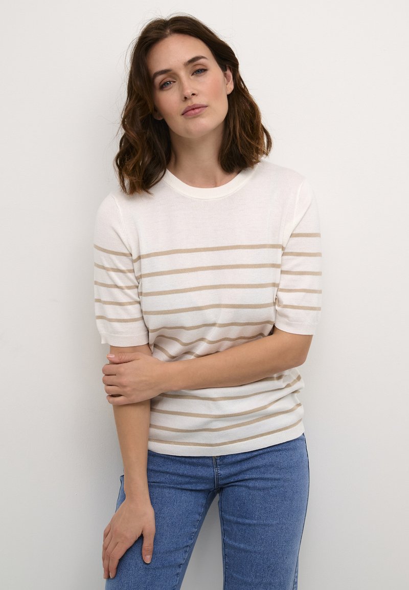 Hvid kortærmet sweater med horisontale beige striber, rund halsudskæring og en blød tekstur, kombineret med blå jeans.