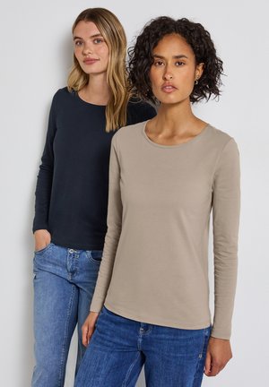 Långärmade toppar i mörk marinblå och ljus beige, med rund halsringning och mjuka, släta texturer, i kombination med denimjeans.