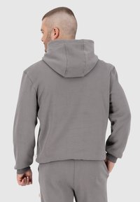 Grijze katoenen hoodie met een cropped ontwerp, geribbelde manchetten en naden, met een eenvoudige, nette esthetiek.