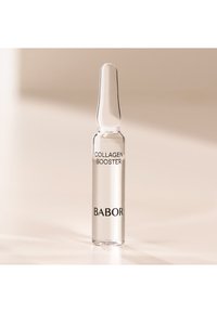 Ampolla de vidrio clara con un extremo cónico. Contiene un líquido etiquetado "COLÁGENO AUMENTADOR" y "BABOR" en texto negro.