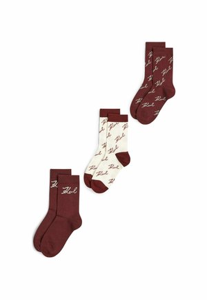 Trois paires de chaussettes d’équipage en bordeaux et crème avec un motif de texte en écriture bordeaux, disposées sur un fond blanc.