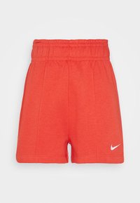 Červené sportovní šortky s elastickým pasem, hladkou texturou a jemnými švy. Obsahují bílé logo Nike swoosh v dolním pravém rohu.