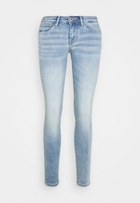 Jeans ajustados azules hechos de denim, con un lavado claro, detalles de desvanecimiento, diseño clásico de cinco bolsillos y cierre de botón metálico.