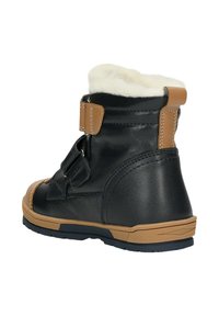 Stivale in pelle nera con accenti color cammello, foderato in pelliccia sintetica, con cinturino regolabile e suola in gomma testurizzata. Design mid-top adatto per il clima più freddo.