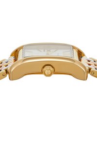 Primer plano de una caja de reloj rectangular en tono dorado con una corona estriada y una pulsera enlazada en tonos dorado, plata y rosa.