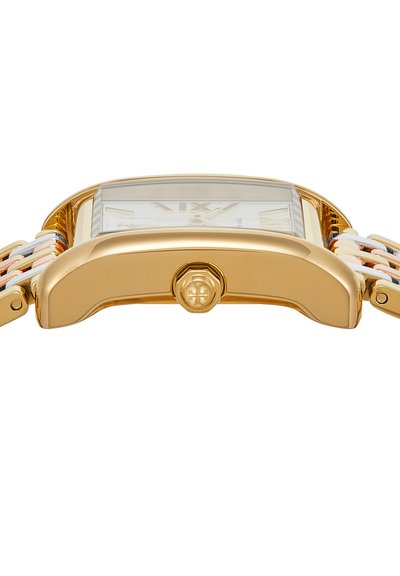 Gros plan sur un boîtier de montre rectangulaire ton or avec une couronne cannelée et un bracelet à maillons dans des tons or, argent et rose.