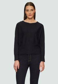 Pull marine foncé avec un col rond et une taille côtelée. Le tissu semble doux, avec des manches longues et une coupe décontractée.