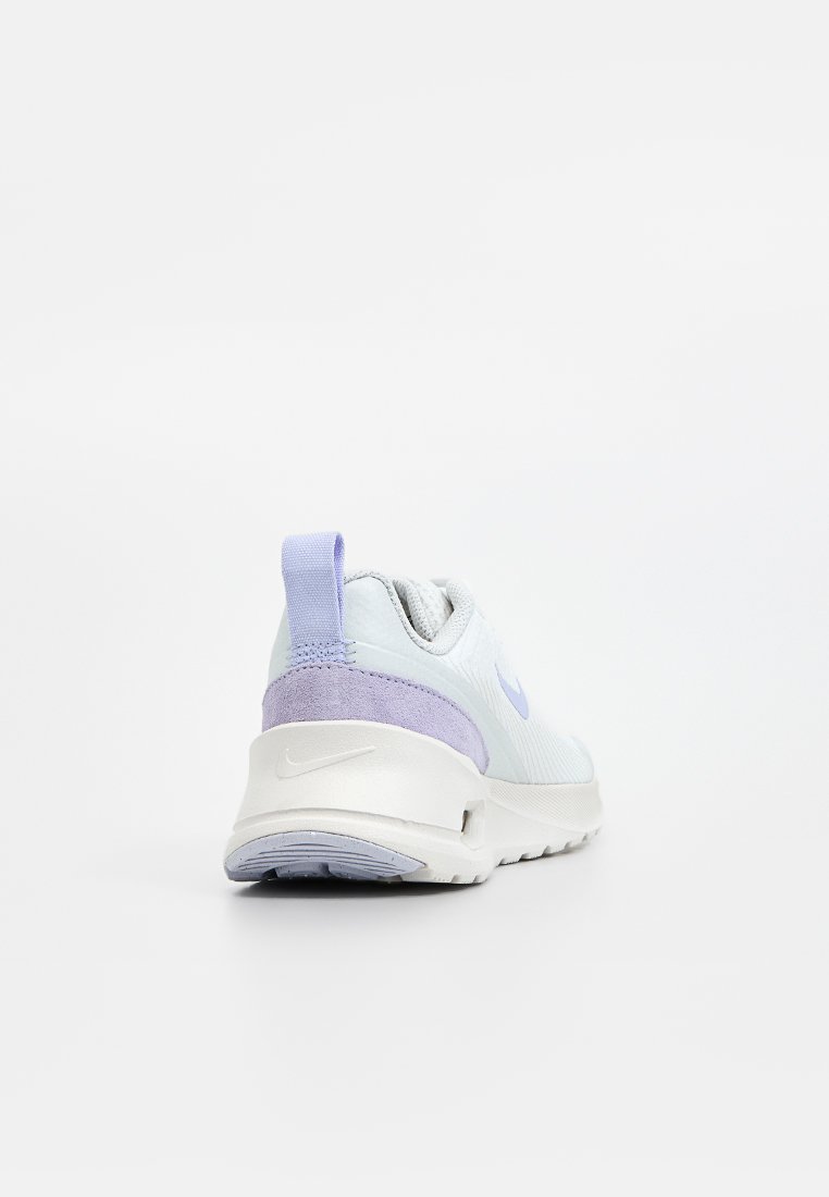 Zapatilla ligera azul con un upper de malla texturizada, acento en el talón de ante morado y una media suela blanca. Presenta una pestaña de agarre y un detalle de logo.